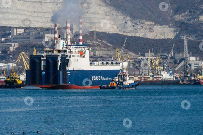 Скачать Паром Ulusoy 5 Sea Line в сопровождении лоцманского буксира движется по Цемесской бухте в открытое море.  Грузовое судно. Размытый фон. Новороссийский морской торговый порт. 22 фотосток Ozero