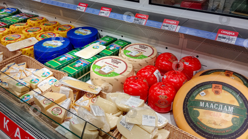 Скачать Гипермаркет Ашан в торговом центре "Сказка". На прилавке-витрине в холодильнике широкий ассортимент сыров от российских производителей продается за рубли. фотосток Ozero