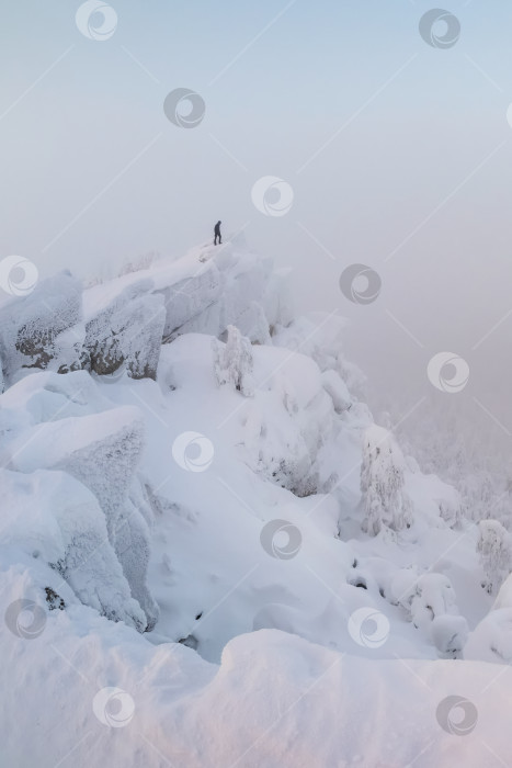 Скачать Вертикальный неземной зимний минималистский пейзаж. Пейзаж скалистых гор с застывшим туманом. фотосток Ozero