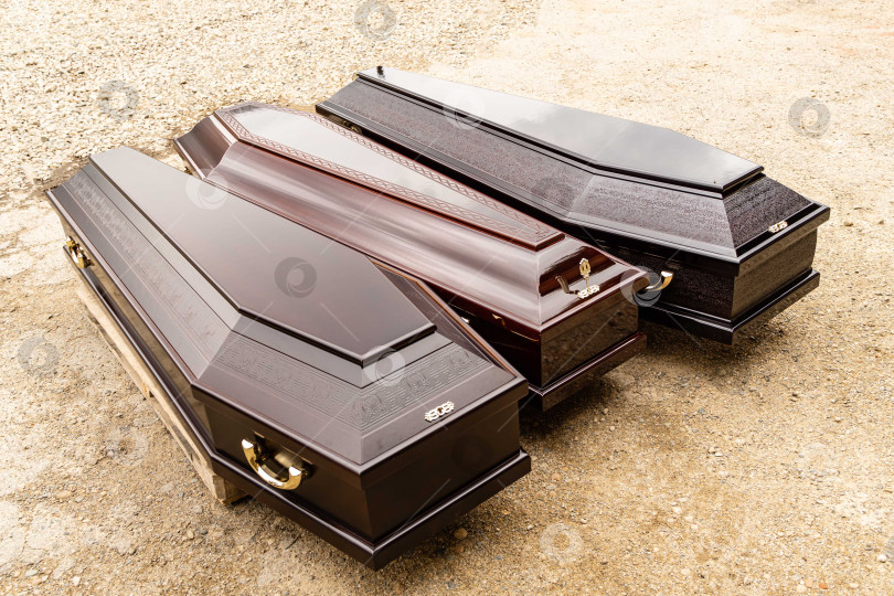 Скачать Элитные гробы на поддоне для транспортировки. Три типа моделей гробов, изготовленных на предприятии Elite Grob enterprise. Крупный план. фотосток Ozero