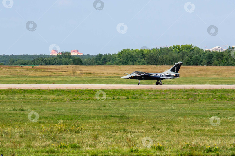 Скачать Французский многоцелевой истребитель четвертого поколения Dassault Rafale приземлился на российской взлетно-посадочной полосе. Самолет движется по взлетно-посадочной полосе с включенными фарами на шасси. МАКС-2011. фотосток Ozero