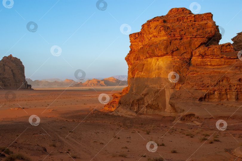 Скачать Иордания. Пустыня Вади Рам. Причудливые формы скал в безлюдной пустыне. Ландшафт похож на марсианские пейзажи. Песок красивого розового цвета в лучах заходящего солнца. Концепция природы для дизайна. фотосток Ozero