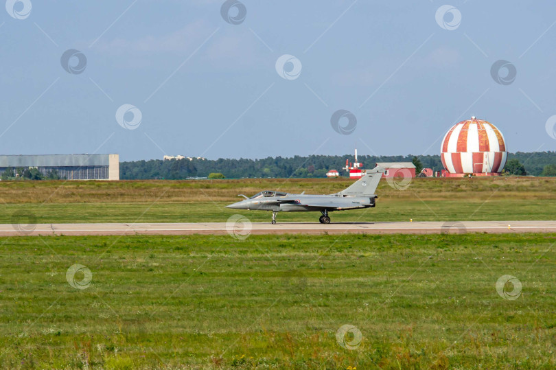 Скачать Французский многоцелевой истребитель четвертого поколения Dassault Rafale приземлился на российской взлетно-посадочной полосе. Самолет движется по взлетно-посадочной полосе с включенными фарами на шасси. МАКС-2011. фотосток Ozero