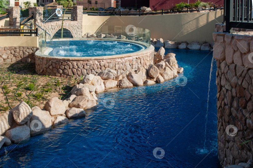 Скачать Иордания. Акаба. "Отель Movenpick Resort and SPA Tala Bay Aqaba 5 звезд" на берегу Красного моря. Территория отеля с множеством бассейнов окружена пальмами и другими экзотическими растениями. фотосток Ozero