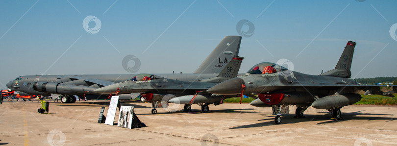 Скачать МАКС-2007. Два американских многофункциональных легких истребителя General Dynamics F-16 Fighting Falcon. На заднем плане американский стратегический бомбардировщик Boeing B-52 "Стратофортресс". фотосток Ozero
