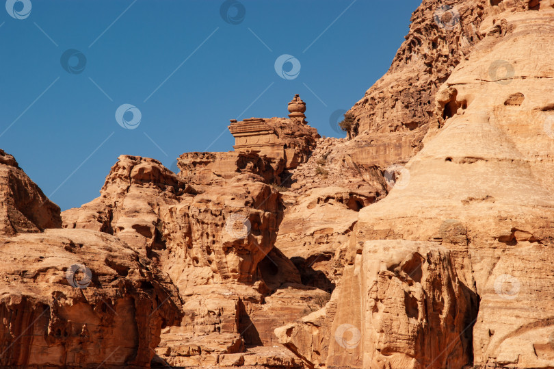 Скачать Узкая дорога к монастырю Ад-Дейр в Петре, Иордания. Горные пейзажи с крутыми пропастями. Дорога между поднимающимися вверх скалами. Скалистые утесы красных, розовых и оранжевых тонов. фотосток Ozero