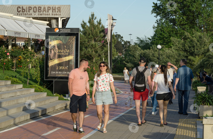 Скачать Люди прогуливаются по красивой набережной в Адлере. Город-курорт, входящий в состав города Сочи. Адлер Сочи, Россия - 18 мая 2021 года фотосток Ozero