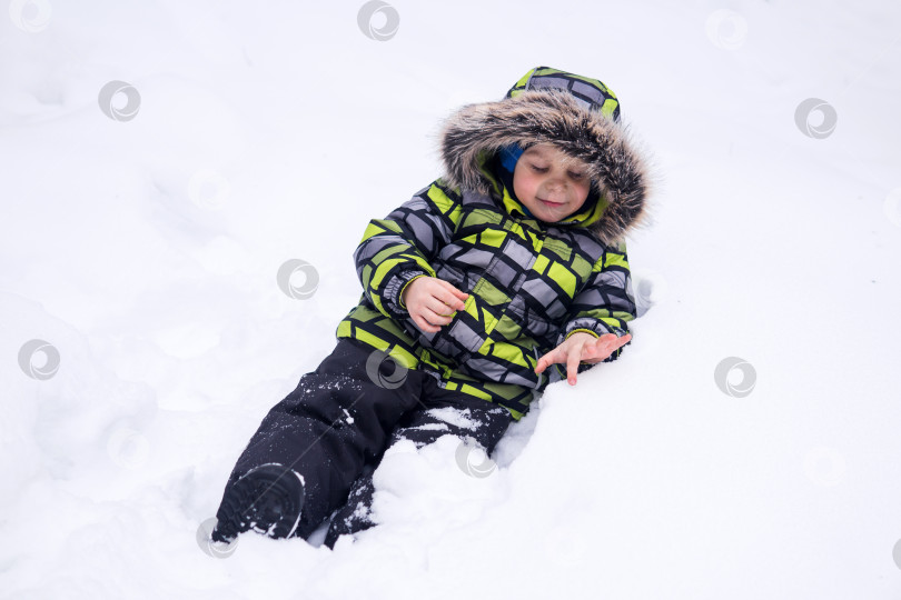 Скачать маленький ребенок, играющий зимой в снегу фотосток Ozero