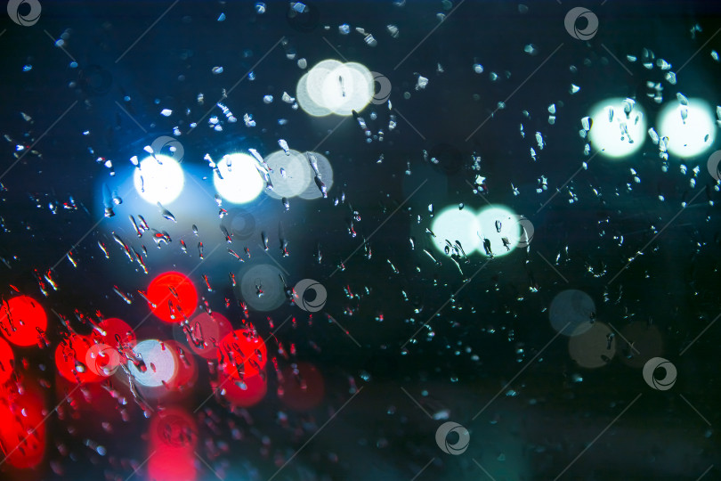 Скачать Капли воды падают на стекло автомобиля ночью во время дождя. фотосток Ozero