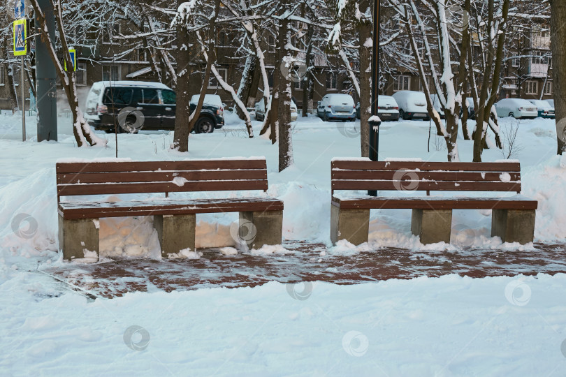 Скачать две деревянные скамейки зимой на снегу. фотосток Ozero