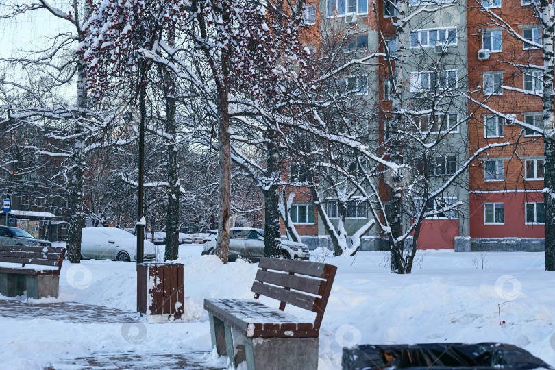 Скачать место для отдыха на скамейке зимой во дворе дома. фотосток Ozero