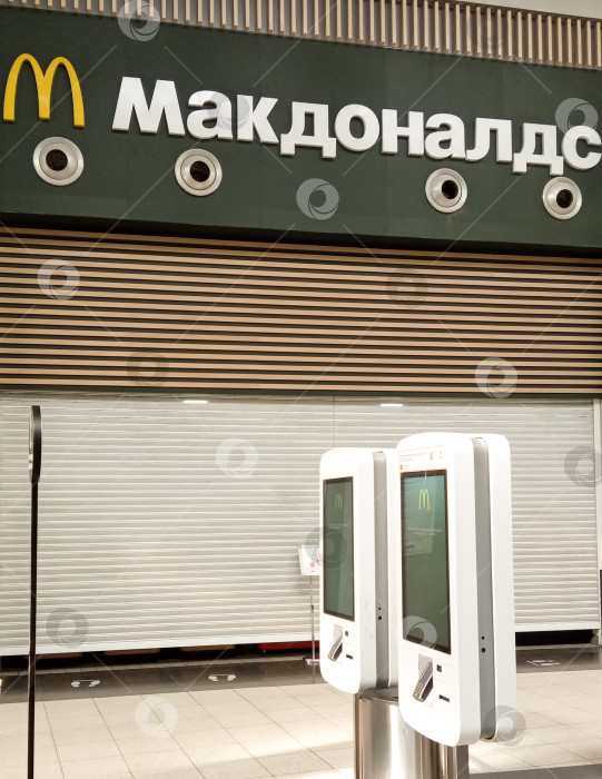 Скачать Ресторан McDonald's в торговом центре "Мега Адыгея" был закрыт из-за санкций. Над опущенными рольставнями - название и логотип McDonald's. Крупный план. фотосток Ozero