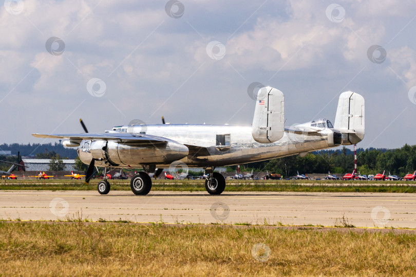 Скачать Американский двухмоторный бомбардировщик North American B-25 "Митчелл" времен Второй мировой войны выруливает со стоянки на взлетно-посадочную полосу для взлета. Red Bull. 100 лет Военно-воздушным силам России. фотосток Ozero