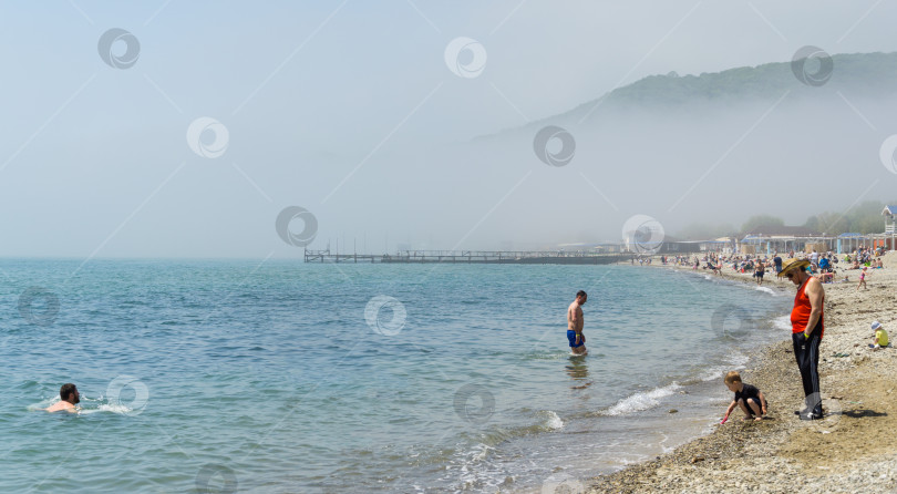 Скачать Красивый морской пейзаж. Туман опустился на пляж с голубой водой Черного моря. Побережье курорта Архипо-Осиповка. Геленджик, Архипо-Осиповка, Россия, 15 мая 2021 года фотосток Ozero