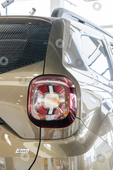 Скачать Крупный план правого заднего фонаря бежевого внедорожника Renault Duster в автосалоне дилерского центра Renault.  Автосалон Renault в Мега Адыгея. фотосток Ozero