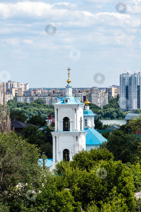 Скачать Действующий православный храм Святого Николая Чудотворца со смотровой площадки. Золотые купола с золотыми православными крестами на голубых крышах храма на фоне голубого неба. фотосток Ozero