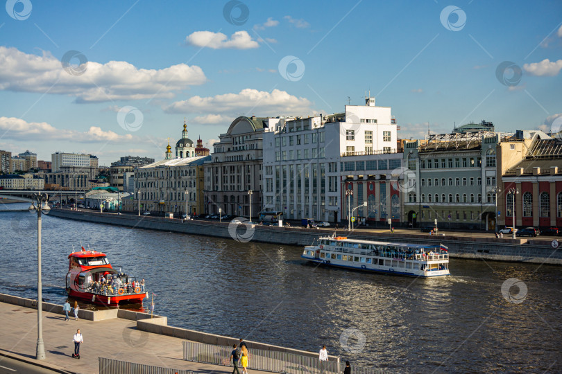 Скачать Москва, Россия - 16 июня 2019 года. Прогулочные катера плывут по Москве-реке в направлении Котельнической набережной. Съемка с наплавного моста. Двухэтажный прогулочный катер с людьми на пирсе фотосток Ozero