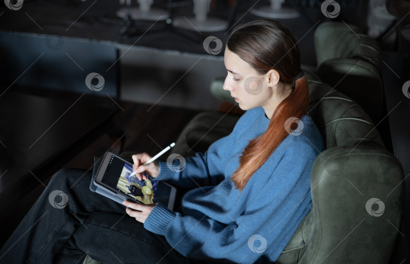 Скачать Девушка сидит в вестибюле отеля или ресторана и рисует на электронном планшете натюрморт с чайником, лимоном и цветами. Концепция вдохновения, творчества, саморазвития, хобби, современного искусства. Современные технологии. фотосток Ozero