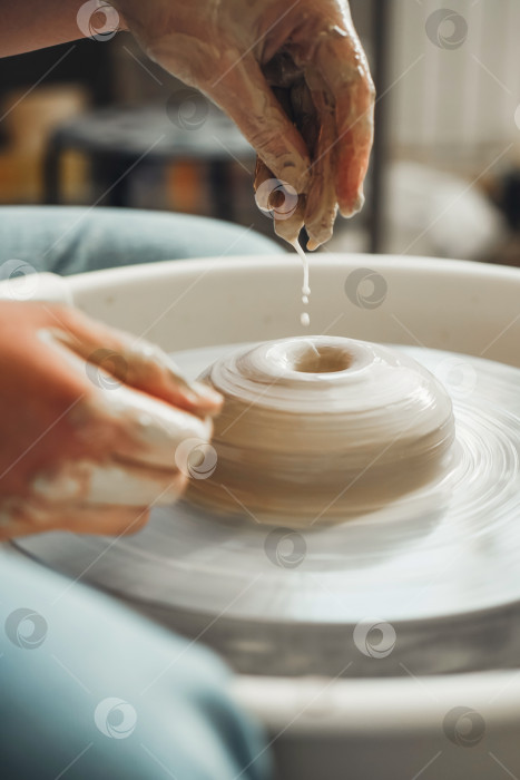 Скачать Красивые женские руки создают глиняное изделие на гончарном круге фотосток Ozero