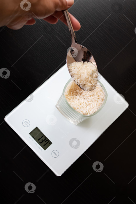 Скачать Стакан с рисом на электронных весах и ложкой фотосток Ozero