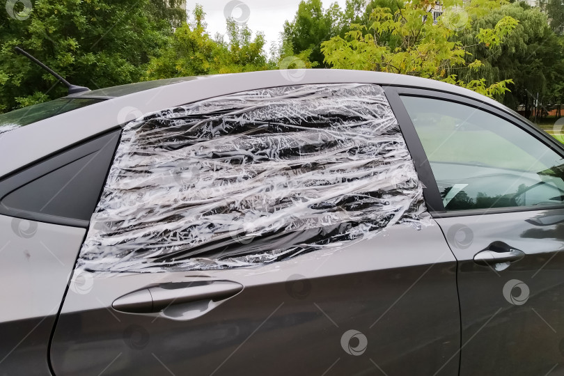Скачать Разбитое автомобильное стекло, заклеенное пленкой крупным планом фотосток Ozero