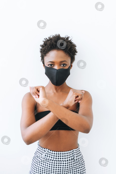 Скачать Красивая молодая афроамериканка в черном топе и маске для лица, выделенная на белом фоне, концепция остановки коронавируса фотосток Ozero