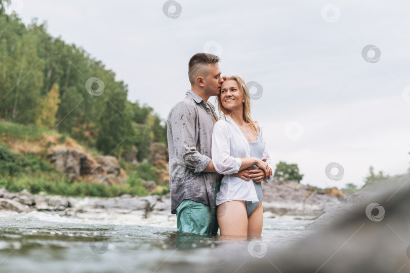 Скачать Счастливая молодая пара влюбленных путешественников целуется в горной реке фотосток Ozero