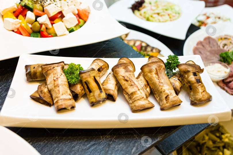 Скачать Фаршированные баклажаны и смешанный салат на праздничном столе фотосток Ozero