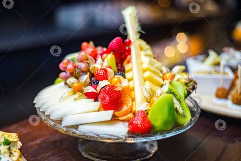 Скачать Изысканный выбор свежесрезанных фруктов на стеклянном блюде фотосток Ozero