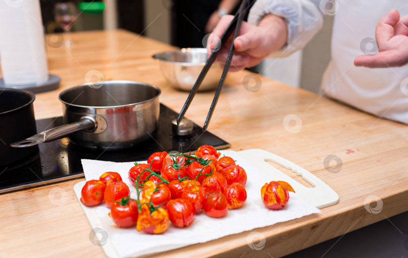 Скачать Шеф-повар готовит запеченные помидоры черри на кухне фотосток Ozero