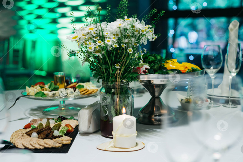 Скачать Элегантная сервировка обеденного стола с сырным блюдом и свежими цветами фотосток Ozero