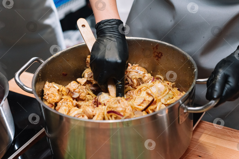 Скачать Шеф-повар готовит курицу в большой металлической кастрюле фотосток Ozero