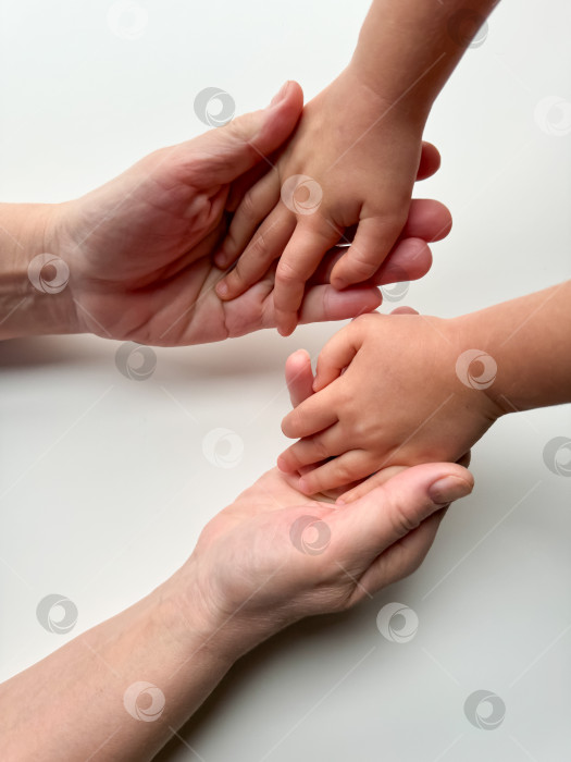 Скачать Руки матерей, держащих детей за руки на белом фоне. фотосток Ozero