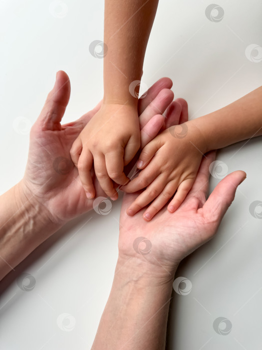 Скачать Руки матерей, держащих детей за руки на белом фоне. фотосток Ozero
