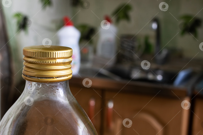 Скачать Бутылка с маслом на фоне посуды и раковин фотосток Ozero