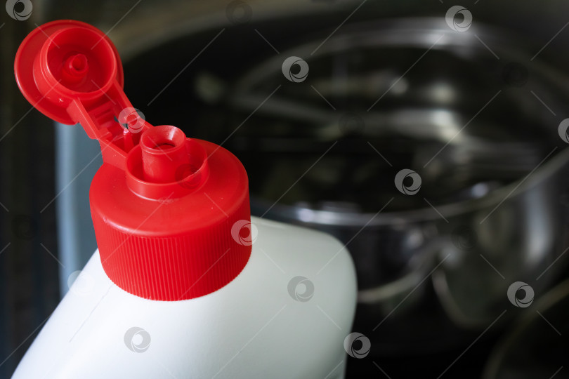 Скачать Крышка от бутылки с мылом для мытья посуды на фоне раковины с посудой фотосток Ozero