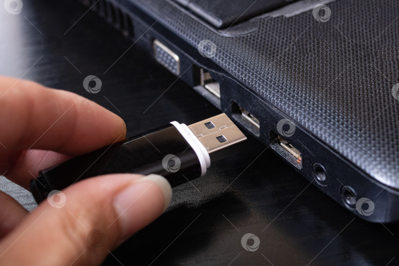 Скачать Черная USB-флешка и ноутбук крупным планом фотосток Ozero