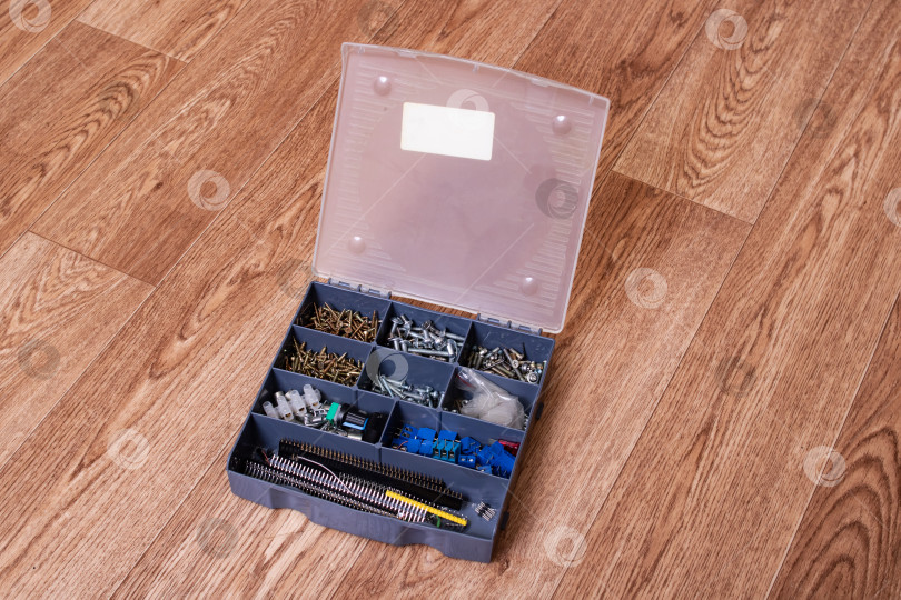 Скачать Различные шурупы в пластиковой коробке на деревянном столе фотосток Ozero