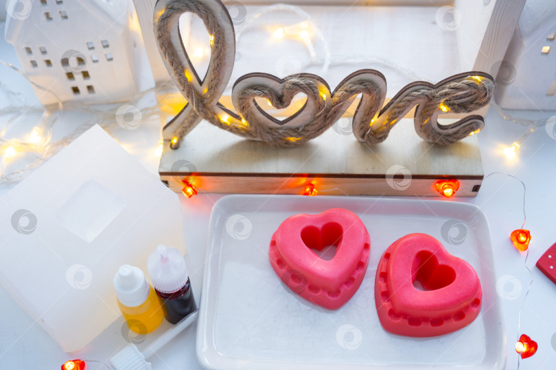 Скачать Домашнее мыло ручной работы в форме сердечек для подарка любимой на День Святого Валентина. Духи и красители, мыльная основа на столе фотосток Ozero