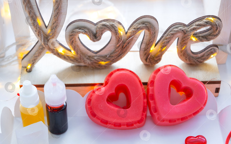 Скачать Домашнее мыло ручной работы в форме сердечек для подарка любимой на День Святого Валентина. Духи и красители, мыльная основа на столе фотосток Ozero