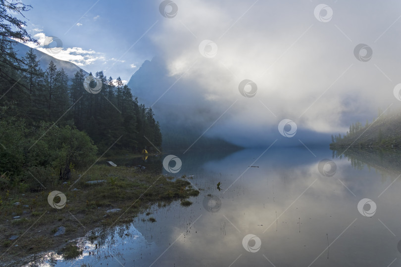 Скачать Облака лежат на поверхности горного озера. фотосток Ozero