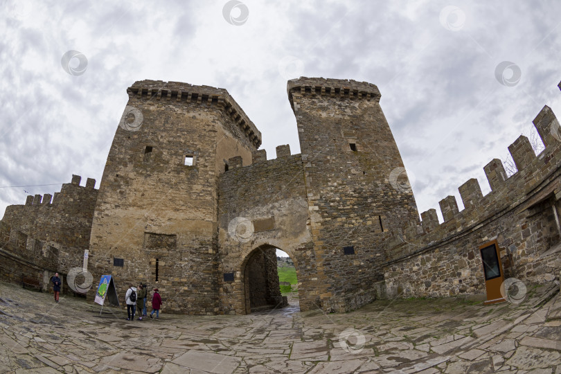 Скачать Генуэзская крепость в Судаке, Крым. Небольшая группа туристов перед входом в крепость. фотосток Ozero