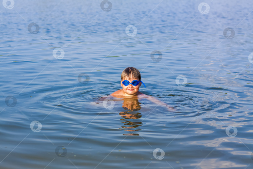 Скачать Счастливый ребенок купается в реке в очень жаркий летний день. Купание в водоемах. Счастливая семья веселится и плещется в воде летом. фотосток Ozero