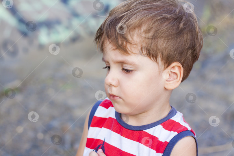 Скачать Портрет маленького мальчика, скорчившего странную гримасу. фотосток Ozero