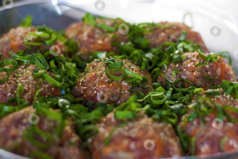 Скачать Сырые фрикадельки, приготовленные из органического мяса, овощей и специй, готовые к запеканию в духовке, являются отличным источником белка. фотосток Ozero