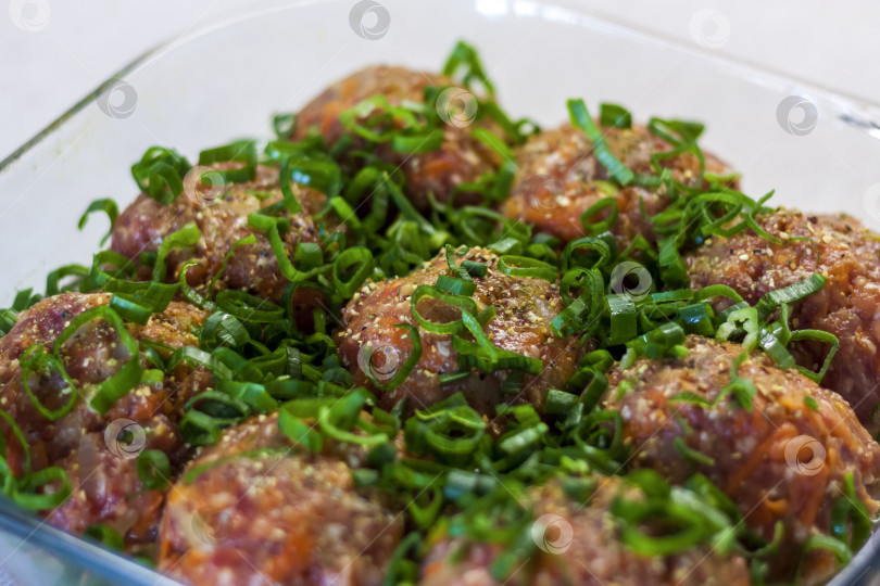 Скачать Сырые фрикадельки, приготовленные из органического мяса, овощей и специй, готовые к запеканию в духовке, являются отличным источником белка. фотосток Ozero