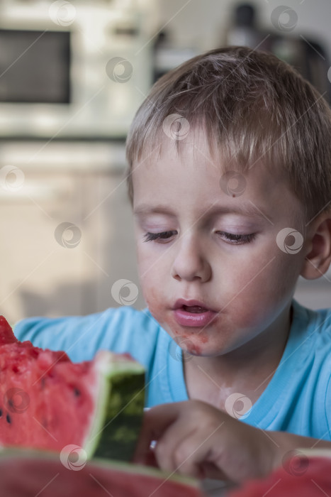 Скачать Милый мальчик ест арбуз дома. Настоящие эмоции без позирования. фотосток Ozero