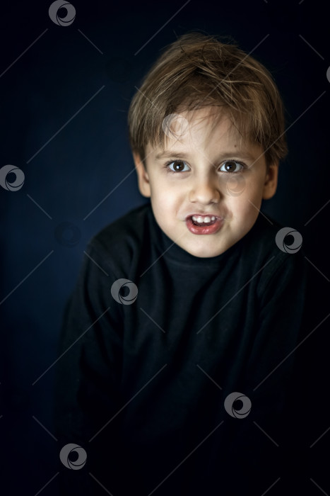 Скачать Лаконичный портрет европейского мальчика. Портрет на темном фоне. фотосток Ozero