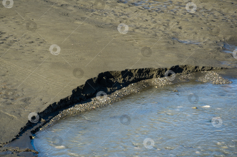 Скачать Пляжная зона с оригинальной текстурой влажного серого песка и воды горной реки Мзымта в Адлере. Отличный фон для любого природного дизайна. фотосток Ozero