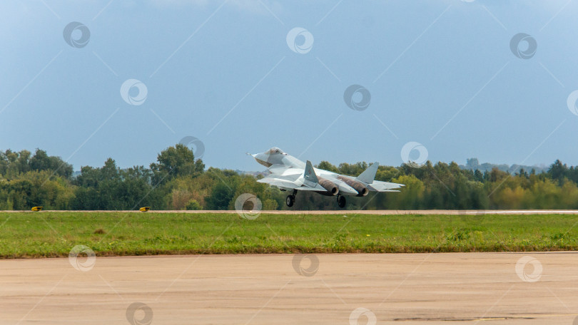 Скачать RMAKS-2013. Крупный план. Российский многоцелевой истребитель пятого поколения Су-57 (НАТО - Felon) приземляется на бетонную взлетно-посадочную полосу после демонстрационного полета. фотосток Ozero